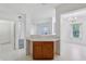 Kitchen with bar seating opens to a living area, featuring white appliances and wooden cabinets at 6017 Riva Ridge Dr, Indianapolis, IN 46237
