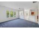Living room features blue carpet, white walls, and abundant natural light from multiple windows at 6017 Riva Ridge Dr, Indianapolis, IN 46237