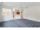 Spacious living room featuring blue carpet and white walls with a view of kitchen at 6017 Riva Ridge Dr, Indianapolis, IN 46237