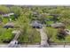 Aerial view of charming single-story home featuring mature trees, long driveway, and inviting backyard with pool and trampoline at 615 W Stop 11 Rd, Indianapolis, IN 46217