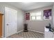 Minimalist bedroom with posters, window, gaming chair, and closet at 615 W Stop 11 Rd, Indianapolis, IN 46217