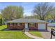 Charming brick home with an attached garage, landscaped yard, and inviting front entrance in a suburban neighborhood at 615 W Stop 11 Rd, Indianapolis, IN 46217