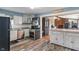 Well-appointed kitchen featuring white cabinetry, stainless steel appliances, and open access to a bright, adjoining room at 615 W Stop 11 Rd, Indianapolis, IN 46217