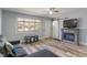 Bright living room with wood-look flooring, fireplace, and a large window offering natural light and modern decor at 615 W Stop 11 Rd, Indianapolis, IN 46217