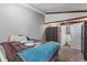 Comfortable bedroom featuring neutral walls, ceiling beams, and an ensuite bathroom at 615 W Stop 11 Rd, Indianapolis, IN 46217