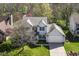 An aerial view of a charming two-story home with a well-manicured lawn and mature trees at 6205 Albury Dr, Indianapolis, IN 46236