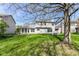 View of the back exterior, featuring a screened-in porch and well-maintained yard at 6205 Albury Dr, Indianapolis, IN 46236