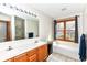 Bathroom featuring a dual sink vanity, bathtub, shower, and window offering natural light at 6205 Albury Dr, Indianapolis, IN 46236