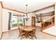 Inviting dining room with chandelier, tile floor, and natural light, next to hardwood stairs at 6205 Albury Dr, Indianapolis, IN 46236