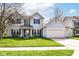 Charming two-story home with blue shutters, a well-manicured lawn, and an attached two-car garage at 6205 Albury Dr, Indianapolis, IN 46236