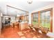 Eat-in kitchen boasts natural wood cabinets, an island, brick flooring, and abundant natural light from large windows at 6205 Albury Dr, Indianapolis, IN 46236