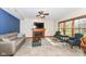 Cozy living room with a fireplace, comfortable seating, and natural light from large windows at 6205 Albury Dr, Indianapolis, IN 46236