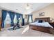 Bright main bedroom features a plush bed, exercise bike, and sunny windows with curtains at 6211 W Bayfront Shores, McCordsville, IN 46055