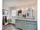 Bathroom featuring a dual sink vanity with granite counters, decorative mirrors, and slate tile floors at 6220 Yellow Birch Ct, Avon, IN 46123