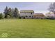 Exterior rear view of home featuring manicured lawn and mature trees at 6220 Yellow Birch Ct, Avon, IN 46123