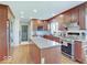 Well-lit kitchen features a stainless steel refrigerator, center island with granite countertop, and wood cabinets at 6220 Yellow Birch Ct, Avon, IN 46123
