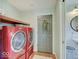 Laundry room with red washer and dryer and a door to the outside at 6220 Yellow Birch Ct, Avon, IN 46123