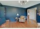 Cozy living room with dark blue walls, hardwood floors, and a comfortable chair at 6220 Yellow Birch Ct, Avon, IN 46123