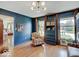 Living room with dark blue walls, hardwood floors, and a view of the front yard at 6220 Yellow Birch Ct, Avon, IN 46123