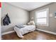 A cozy bedroom features a window, hardwood floors, and a comfy bed with stuffed animal decor at 637 Berkley Rd, Indianapolis, IN 46208
