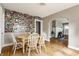 Bright dining room with wood floors, white chairs and table, opening up to the living room and kitchen at 637 Berkley Rd, Indianapolis, IN 46208