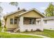 Charming bungalow with a brick porch, chimney, yellow siding, and well-maintained landscaping in a residential neighborhood at 637 Berkley Rd, Indianapolis, IN 46208