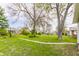 Expansive front yard with lush green grass, large trees, and a walking path, showcasing the property's curb appeal at 637 Berkley Rd, Indianapolis, IN 46208