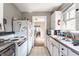 Functional kitchen featuring white appliances and cabinetry, with a view to the dining room at 637 Berkley Rd, Indianapolis, IN 46208
