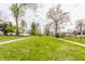 Lush green neighborhood with sidewalks, grassy median, and beautiful mature trees at 637 Berkley Rd, Indianapolis, IN 46208