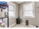 A small pantry room featuring two windows, a black trash can, and a metal storage rack at 637 Berkley Rd, Indianapolis, IN 46208