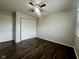 A bedroom featuring dark wood-look flooring, a ceiling fan, and a closet at 6458 Lupine Ter, Indianapolis, IN 46224