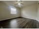 A bedroom featuring dark wood-look flooring, a ceiling fan, and a sunlit window at 6458 Lupine Ter, Indianapolis, IN 46224
