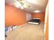 Spacious orange bedroom featuring a ceiling fan, carpeted floors, and natural lighting at 7121 Fields Way, Indianapolis, IN 46239