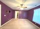 Bedroom with a ceiling fan, painted purple walls, carpet floors and door to the walk-in closet at 7121 Fields Way, Indianapolis, IN 46239