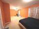 Spacious orange bedroom featuring a ceiling fan, carpeted floors, and natural lighting at 7121 Fields Way, Indianapolis, IN 46239