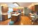 This kitchen features wood cabinets, stainless steel appliances, an island, and hardwood floors at 7121 Fields Way, Indianapolis, IN 46239