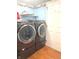 Modern laundry room featuring a washer, dryer, laminate floors, and nautical themed decorations at 7121 Fields Way, Indianapolis, IN 46239
