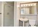 Bathroom with shower, pedestal sink, and mirrored vanity, offering a clean and functional space at 7206 Halden Pl, Indianapolis, IN 46214