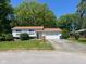 Charming two-story home with a well-maintained lawn, attached garage, and mature trees at 7206 Halden Pl, Indianapolis, IN 46214