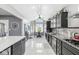 Well-lit kitchen with black cabinets, stainless steel appliances, granite countertops and a dining area at 7280 E Patricia Dr, Camby, IN 46113