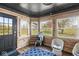 Charming sunroom with wood paneling, multiple windows, and cozy seating, perfect for relaxation at 7280 E Patricia Dr, Camby, IN 46113