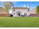 Rear exterior view of home featuring a large backyard, patio, lush green grass and a sturdy wooden fence at 825 Palisades Ct, Greenwood, IN 46143
