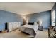 Cozy bedroom featuring a queen bed, textured blue walls, and a white dresser with modern decor at 825 Palisades Ct, Greenwood, IN 46143