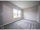 A clean bedroom with light gray walls, gray carpet, white trim, and natural light from the window at 844 Fireside Dr, Greenwood, IN 46143