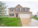 Two-story home showcasing brick and stone with a two-car garage and well-maintained lawn at 844 Fireside Dr, Greenwood, IN 46143