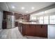 A spacious kitchen featuring dark wood cabinets, a stainless steel refrigerator and a center island at 844 Fireside Dr, Greenwood, IN 46143