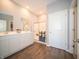 Modern bathroom featuring double sinks, a glass-enclosed shower, and wood-look flooring at 8502 Hemingway Dr, Indianapolis, IN 46239