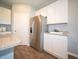 White cabinets, stainless steel refrigerator, granite countertops, and wood floors enhance the kitchen at 8502 Hemingway Dr, Indianapolis, IN 46239