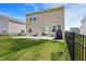 Backyard featuring a concrete patio, well maintained lawn, and dark wrought iron fence at 8583 Strabet Dr, Pendleton, IN 46064