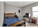 Comfortable bedroom with a wood-framed bed, natural light, and a dedicated workspace setup at 8583 Strabet Dr, Pendleton, IN 46064